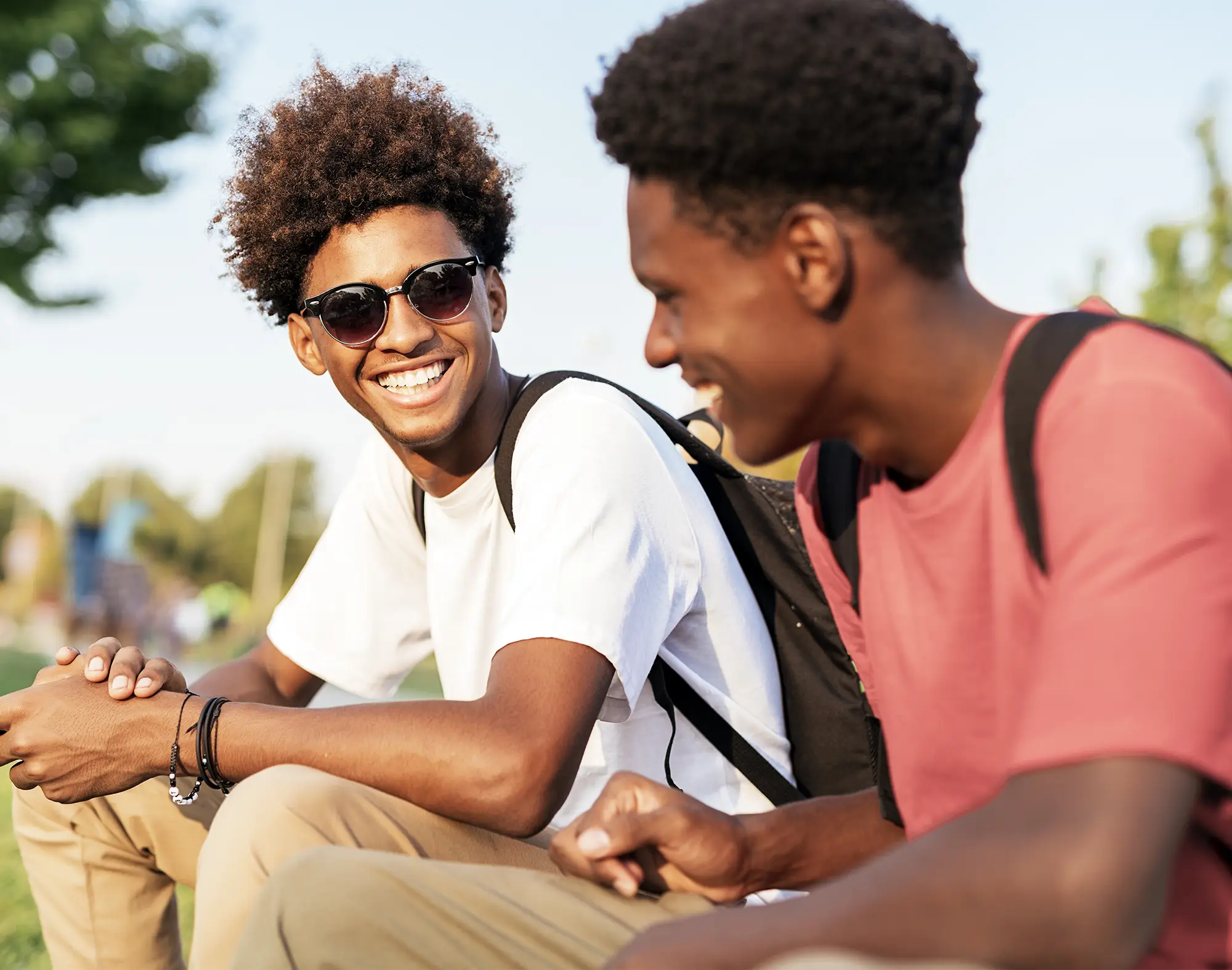 Two students laughing together on a sunny day